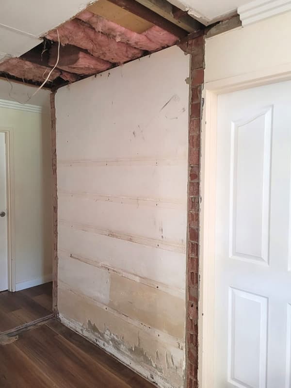 Internal brick wall with ceiling plaster removed ahead of opening